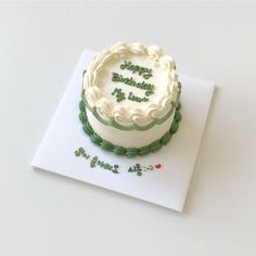 a white cake with green frosting on top