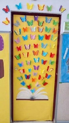 an open book with butterflies on it in front of a bulletin board that is decorated