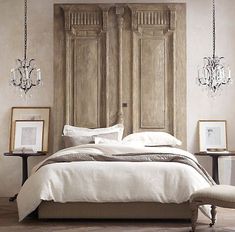 a bed with white linens and chandelier hanging from it's headboard