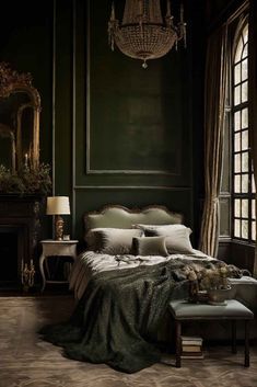 a bedroom with dark green walls and an ornate chandelier hanging from the ceiling