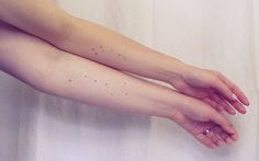 a woman's arm with small dots on it