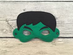 a green mask with black hair and eyes