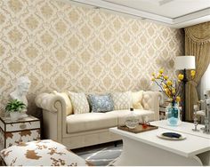 a living room filled with furniture next to a wallpaper covered in gold and white damask