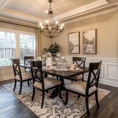 a dinning room table with chairs and a chandelier