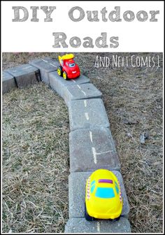 a toy car is parked on the side of a concrete block wall in front of a child's play area