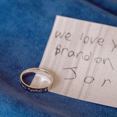 a wedding ring sitting on top of a piece of paper that says we love you