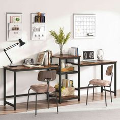 two desks with chairs and books on them in front of a wall mounted calendar