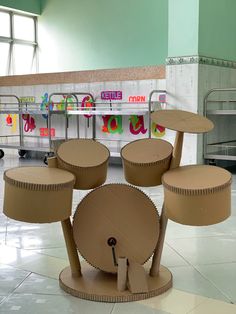 several cardboard drums are on display in front of a counter with colorful signs behind them