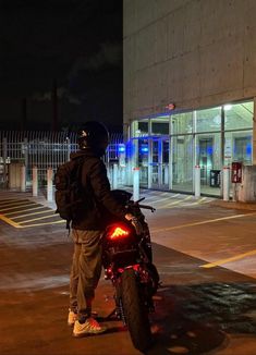 a man riding on the back of a motorcycle at night