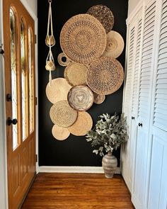 an entry way with baskets hanging on the wall and a potted plant next to it