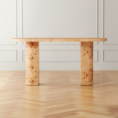 a wooden table sitting on top of a hard wood floor next to a white wall