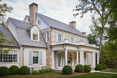 a large house with white trim and blue shutters