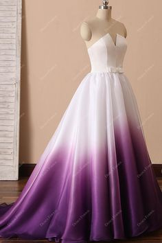 a white and purple wedding dress on display