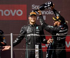 two men standing on top of a race podium