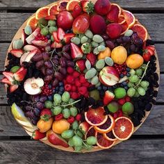 a platter filled with fruit on top of a wooden table