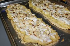 two pieces of food sitting on top of a metal baking pan covered in white frosting