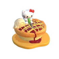 a hello kitty figurine sitting on top of a pie with an ice cream scooper