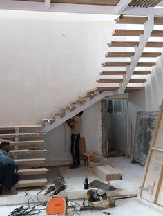 two men are working on an unfinished staircase