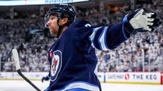 a hockey player with his arms in the air and one hand out, on the ice