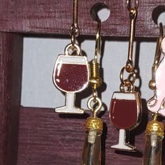 three wine bottles and two glass charms hanging from hooks