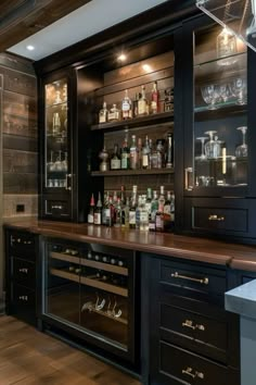 a bar with lots of bottles and glasses on the top shelf, along with shelves filled with liquor