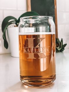 a large glass jar filled with liquid sitting on top of a counter next to a potted plant