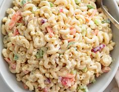 a white bowl filled with macaroni and peas