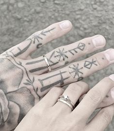 a person with tattoos on their hands and fingers