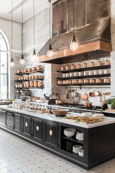 a kitchen with lots of pots and pans hanging from the ceiling, along with lights