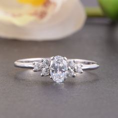 three stone diamond ring sitting on top of a table