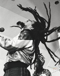 a man with dreadlocks singing into a microphone