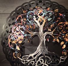 a metal tree with lots of different colored circles on it's trunk and branches