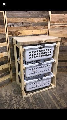 three white plastic baskets stacked on top of each other in front of wooden pallets