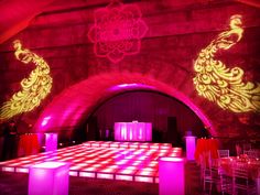 an empty dance floor is lit up with red and yellow lights in the dark room