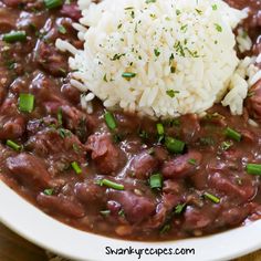 a white plate topped with meat and rice covered in gravy, garnished with parsley