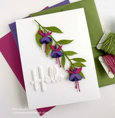 a card with some flowers on it next to yarn and scissors, which says hello