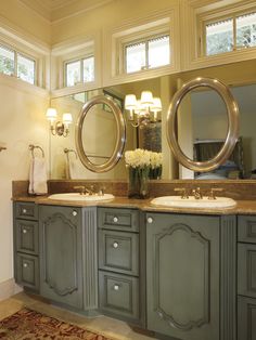 a large bathroom with double sinks and two round mirrors on the wall, along with an area rug