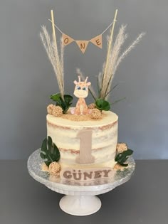 there is a cake that has been decorated with plants and animals on it, along with bunting