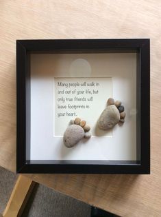 two rocks in a shadow frame with a poem written on the rock and one is sitting next to it