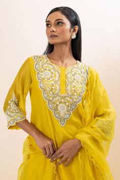 Yellow kurta with floral embroidered yoke and cuffs. Paired with a pant and dupatta.
Components: 3
Pattern: Hand Embroidery
Type Of Work: Floral, Chid, Pearls
Neckline: Round Neck
Sleeve Type: Three Quarter Sleeves
Fabric: Kurta: Chanderi, Pant: Bamber Silk, Dupatta: Organza, Lining: Mul Cotton
Color: Yellow
Other Details: 
Attached inner lining
Scallop trimmed dupatta
Occasion: Sangeet - Aza Fashions Festive Straight Kurta Sets With Embroidered Border, Wedding Palazzo Set With Straight Kurta And Embroidered Border, Wedding Palazzo Set With Embroidered Border And Straight Kurta, Wedding Palazzo Set With Embroidered Border For Festivals, Chanderi Set With Embroidered Border And Straight Kurta, Designer Straight Kurta Sets With Embroidered Border, Chanderi Sets With Embroidered Border For Navratri, Wedding Straight Kurta Sets With Embroidered Border, Wedding Sets With Embroidered Border Straight Kurta