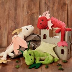 two stuffed animals sitting next to each other in front of a castle and dragon figurine