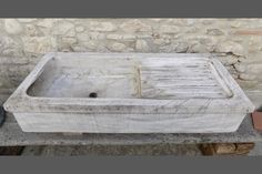 an old stone sink sitting on top of a cement slab