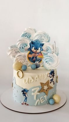 a blue and white birthday cake with sonic the hedgehog on it's top