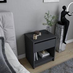 a small black table sitting on top of a wooden floor next to a white bed