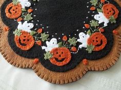 a black and orange halloween placemat with ghost, pumpkins and jack - o'- lanterns on it