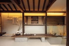 a wooden table sitting in the middle of a room next to a bathtub and sink