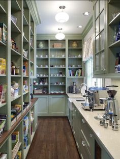 a kitchen filled with lots of green cupboards and counter top space next to a coffee maker