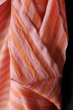 an orange and pink striped scarf hanging on a wall