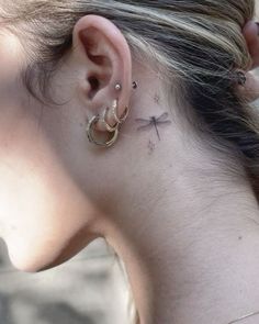 a woman with a small cross behind her ear