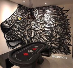 a black and white drawing of a tiger on the wall next to a table with poker chips